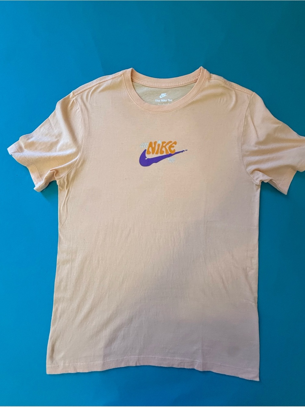 Nike Short Sleeve Graphic Tee in Cream with Purple & Orange Logo